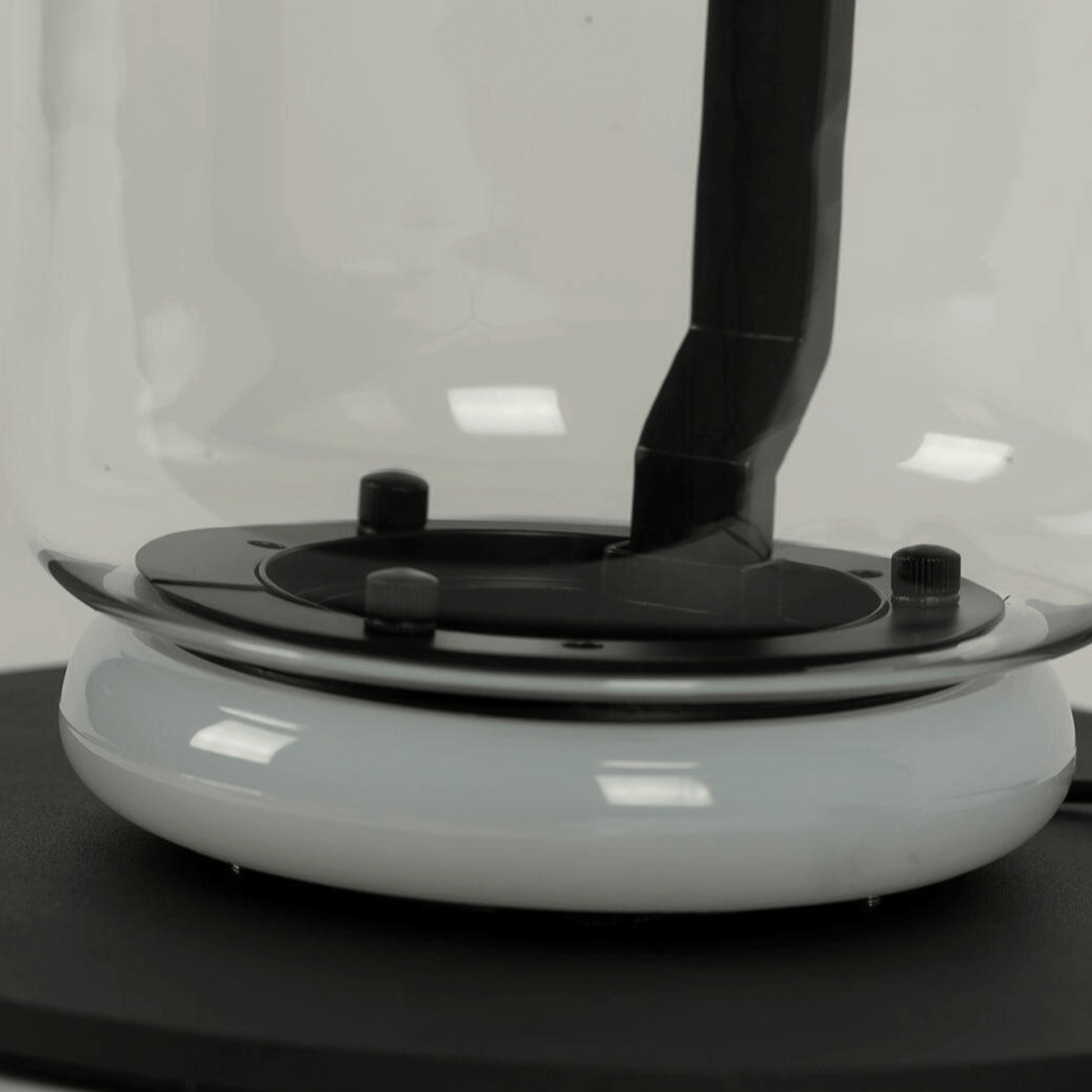 Close-up of a white and black electronic device on a reflective surface with a blurred background