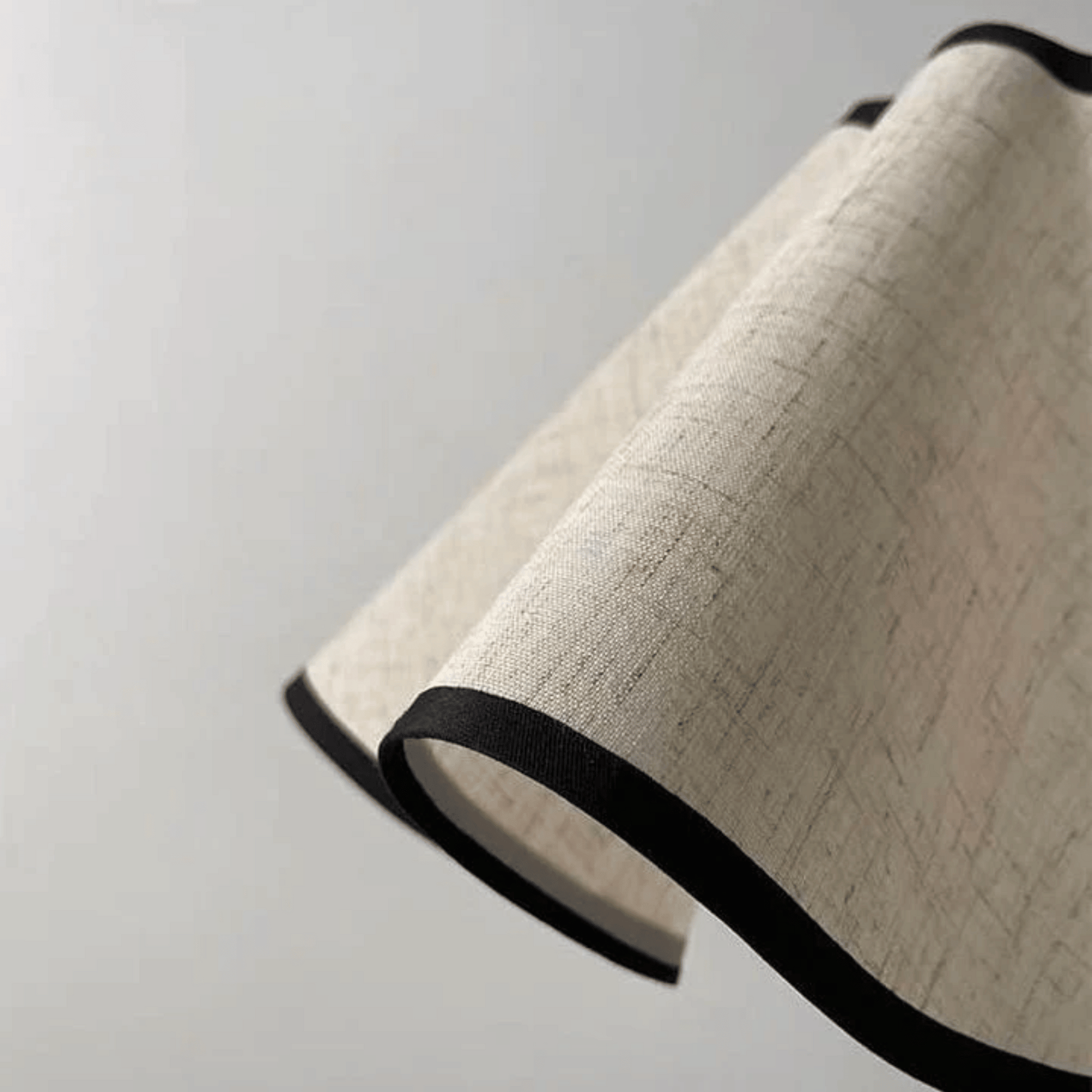 Textured lampshade with black trim on a light gray background
