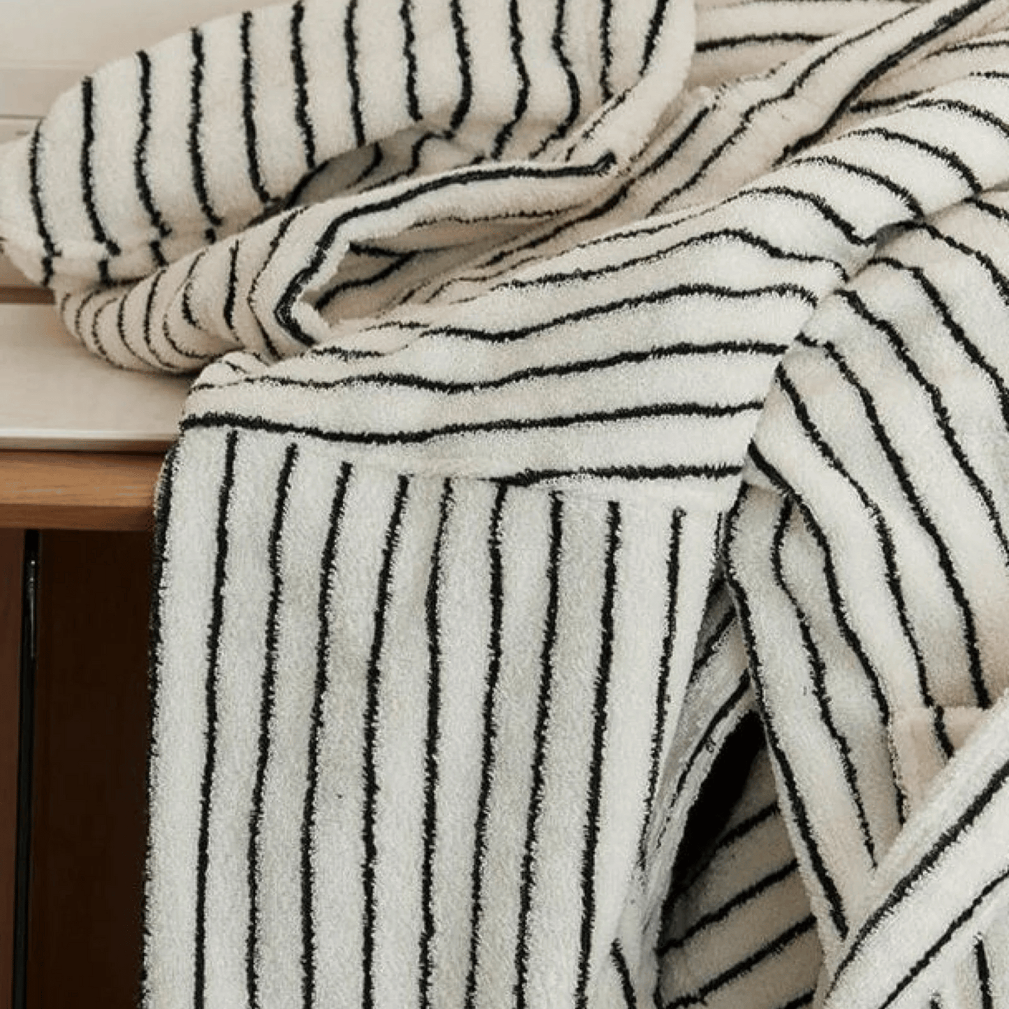 Black and white striped towel draped over a wooden surface