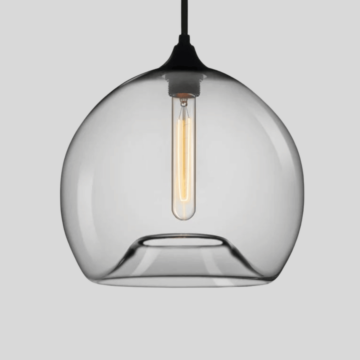 Clear glass pendant light with a black fixture on a gray background