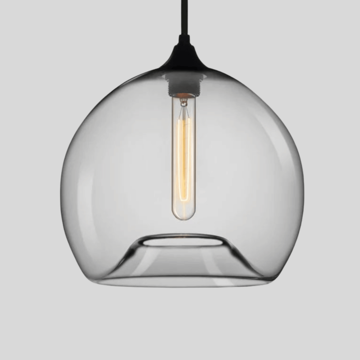 Clear glass pendant light with a black fixture on a gray background