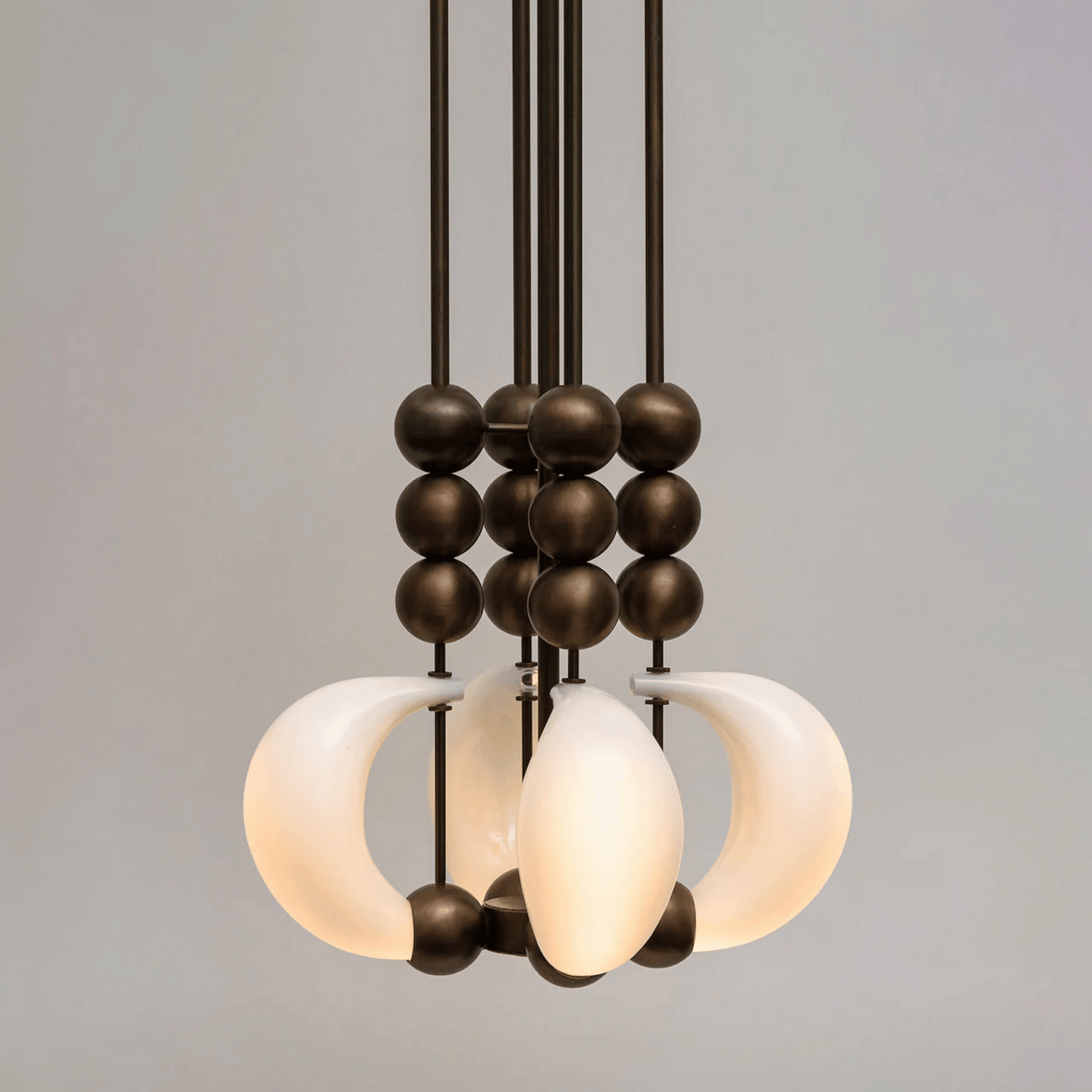 Modern chandelier with glass shades and metal accents on a gray background