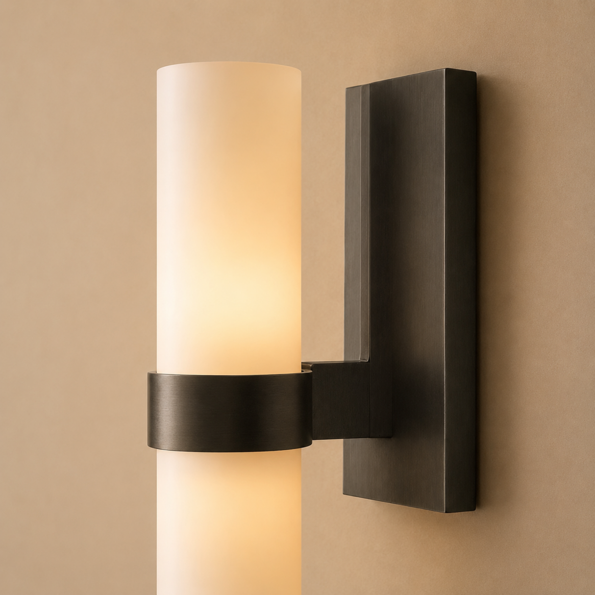 Modern wall sconce with a cylindrical glass shade on a beige wall.