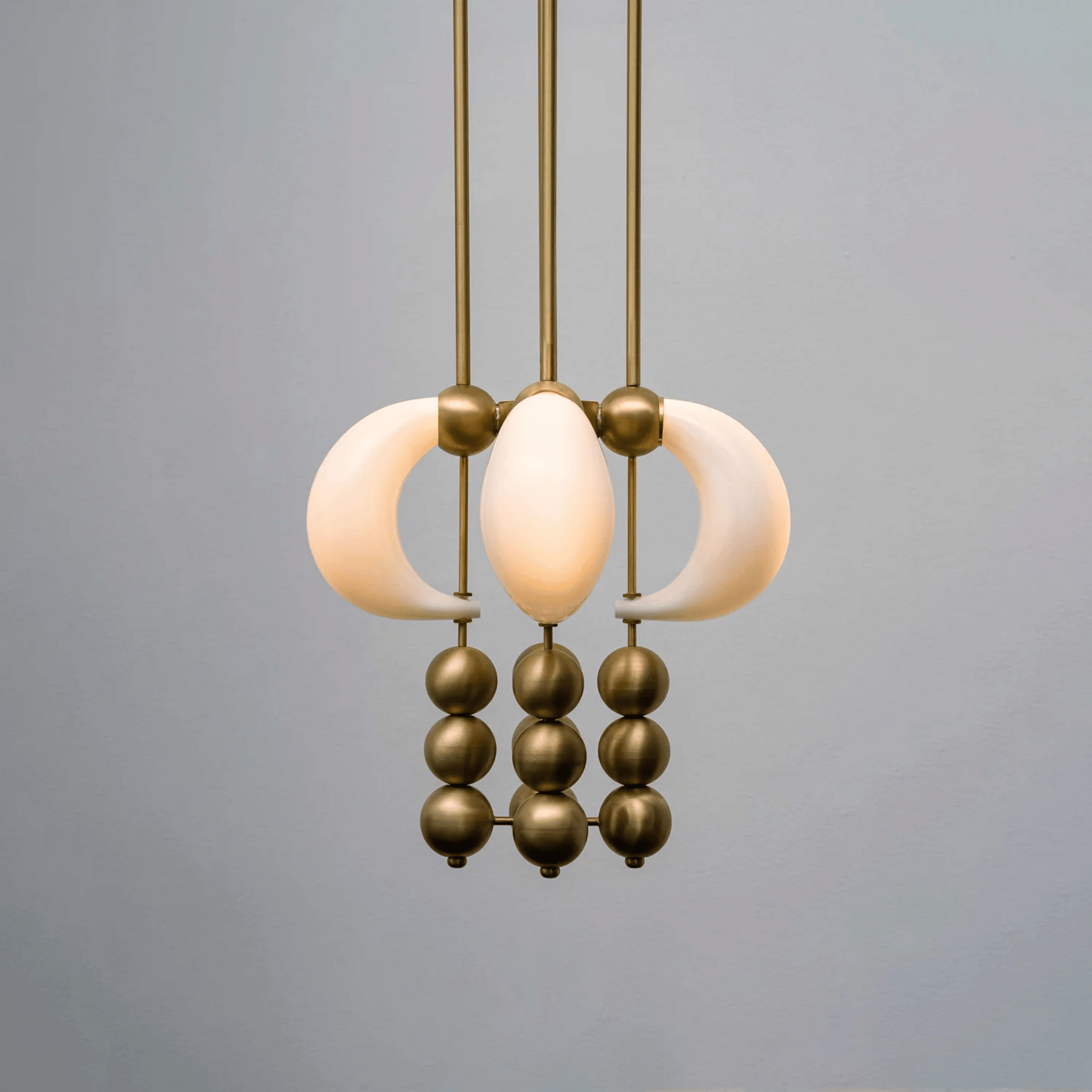 Modern pendant light with gold and white design on a gray background