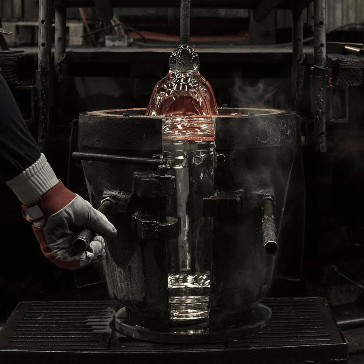 Person handling a glowing metal object in a workshop setting