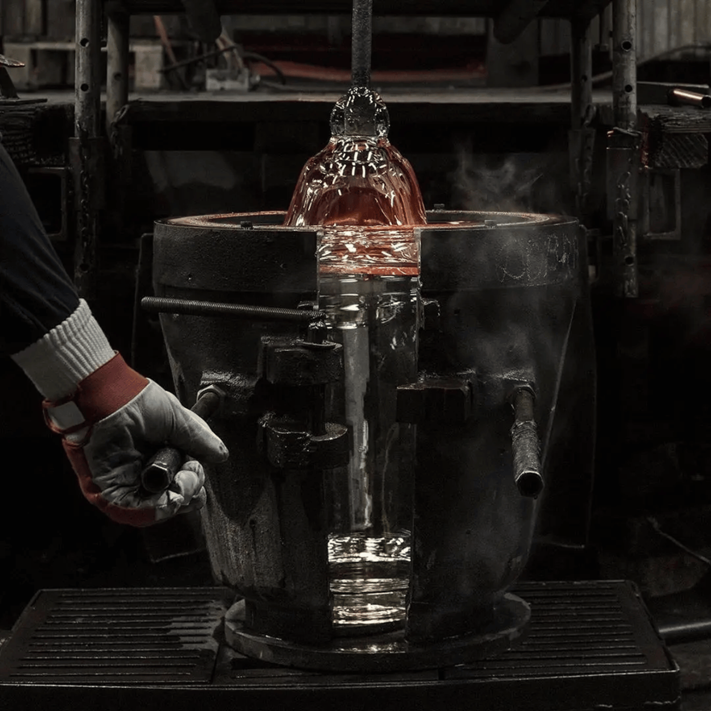 Person handling a glowing metal object in a workshop setting