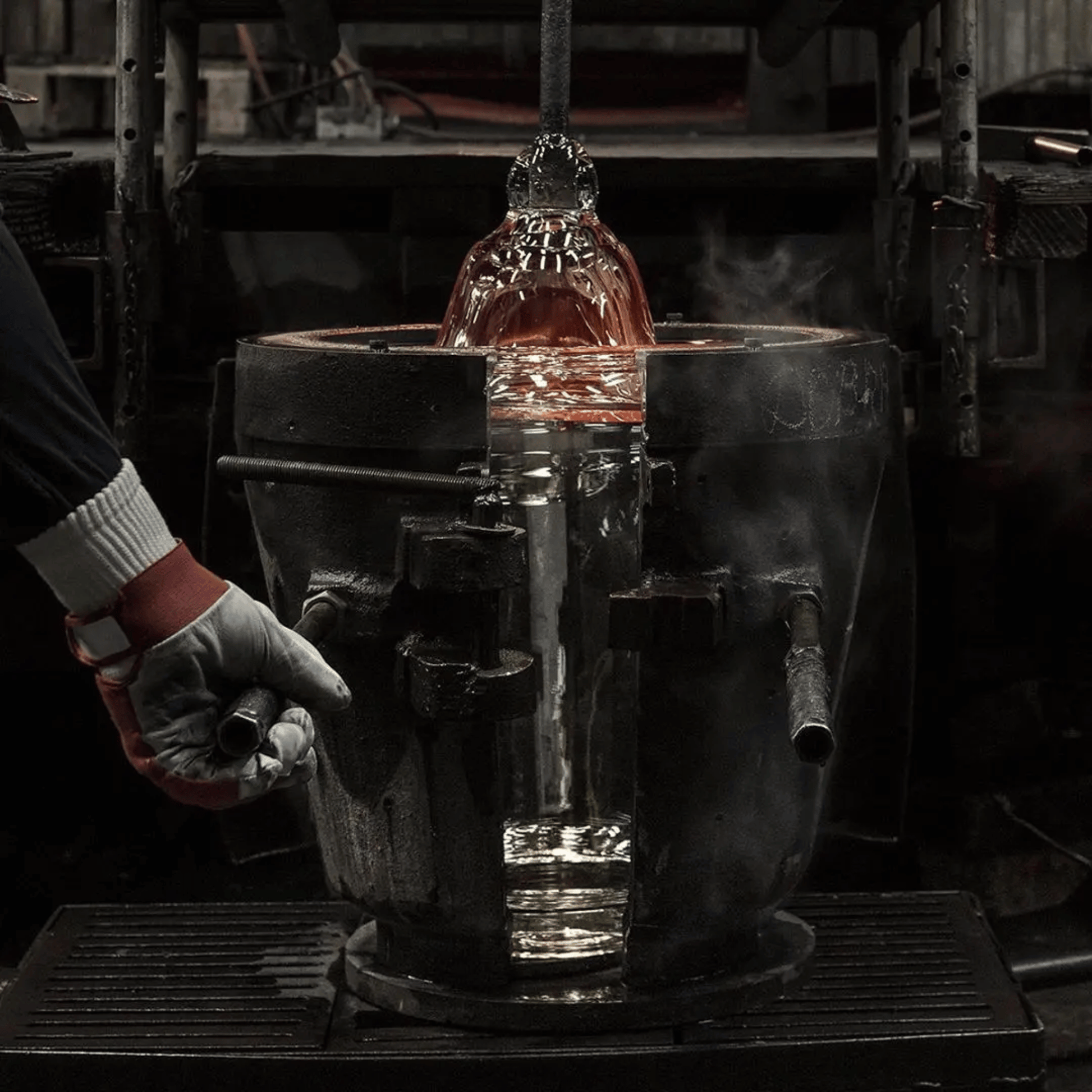 Person handling a glowing metal object in a workshop setting