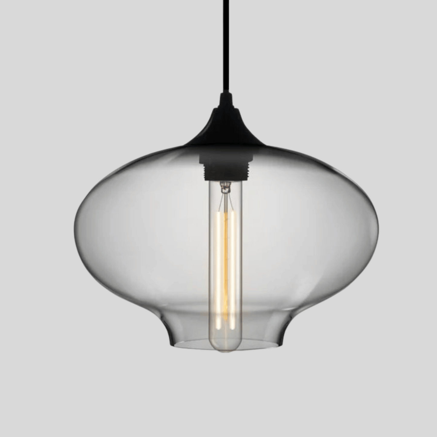 Clear glass pendant light with black fixture on a gray background