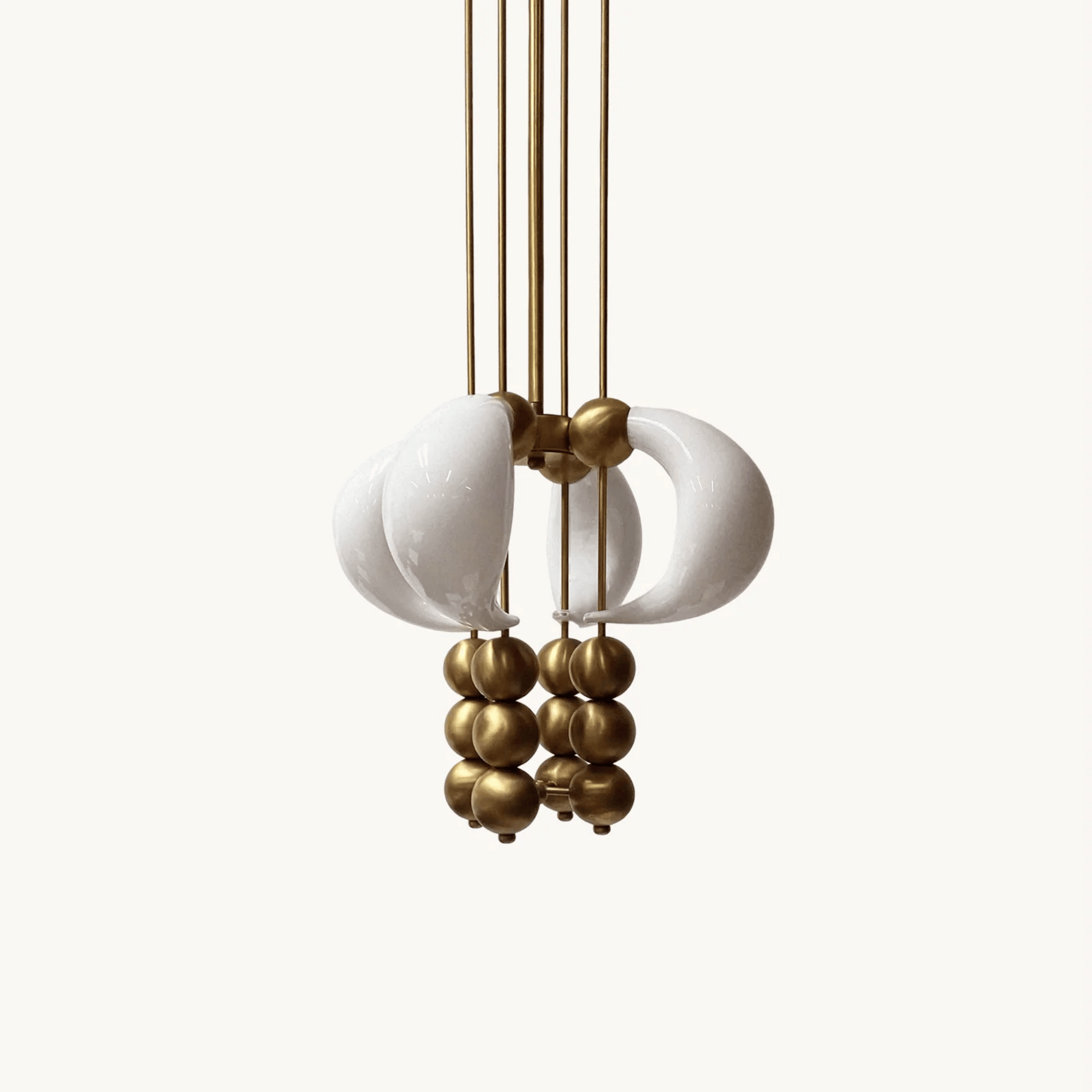 Chandelier with white ceramic balls and gold metal accents on a white background
