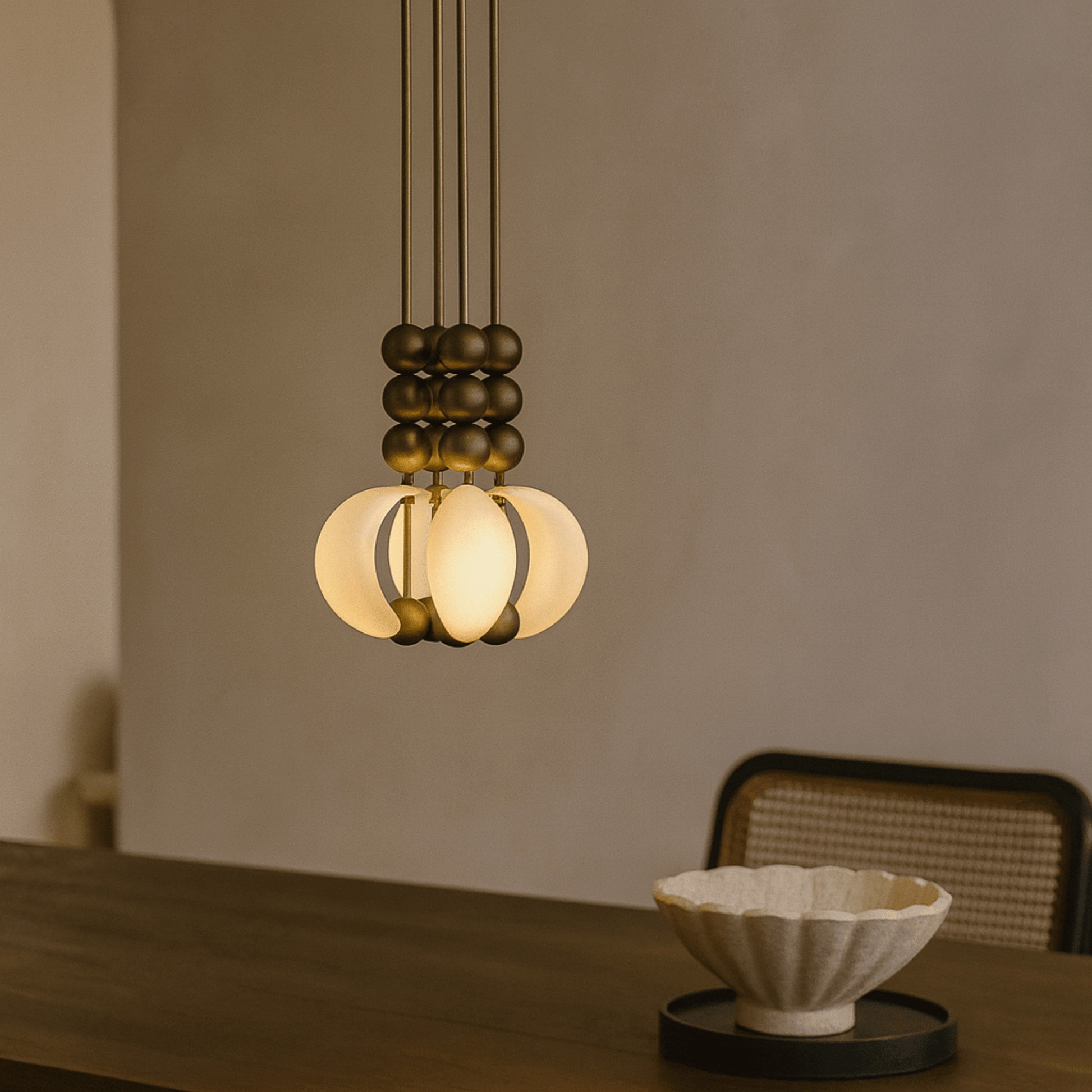 Modern pendant light hanging above a wooden table with a blurred background