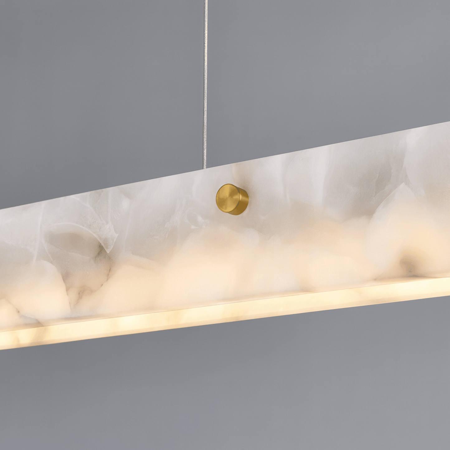 Marble-textured pendant light with gold fixture on a gray background
