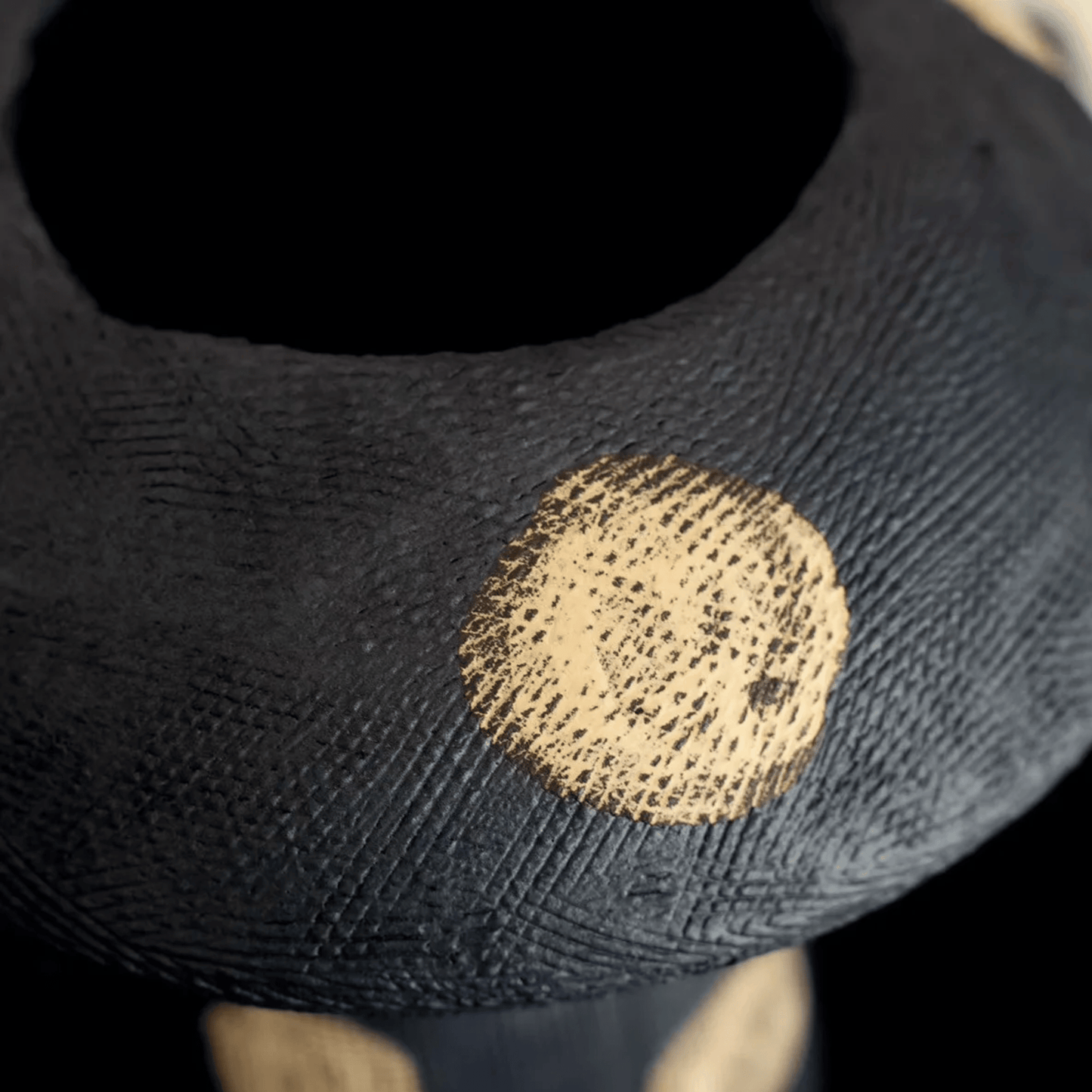 Black sock with a gold circular stain on a dark background
