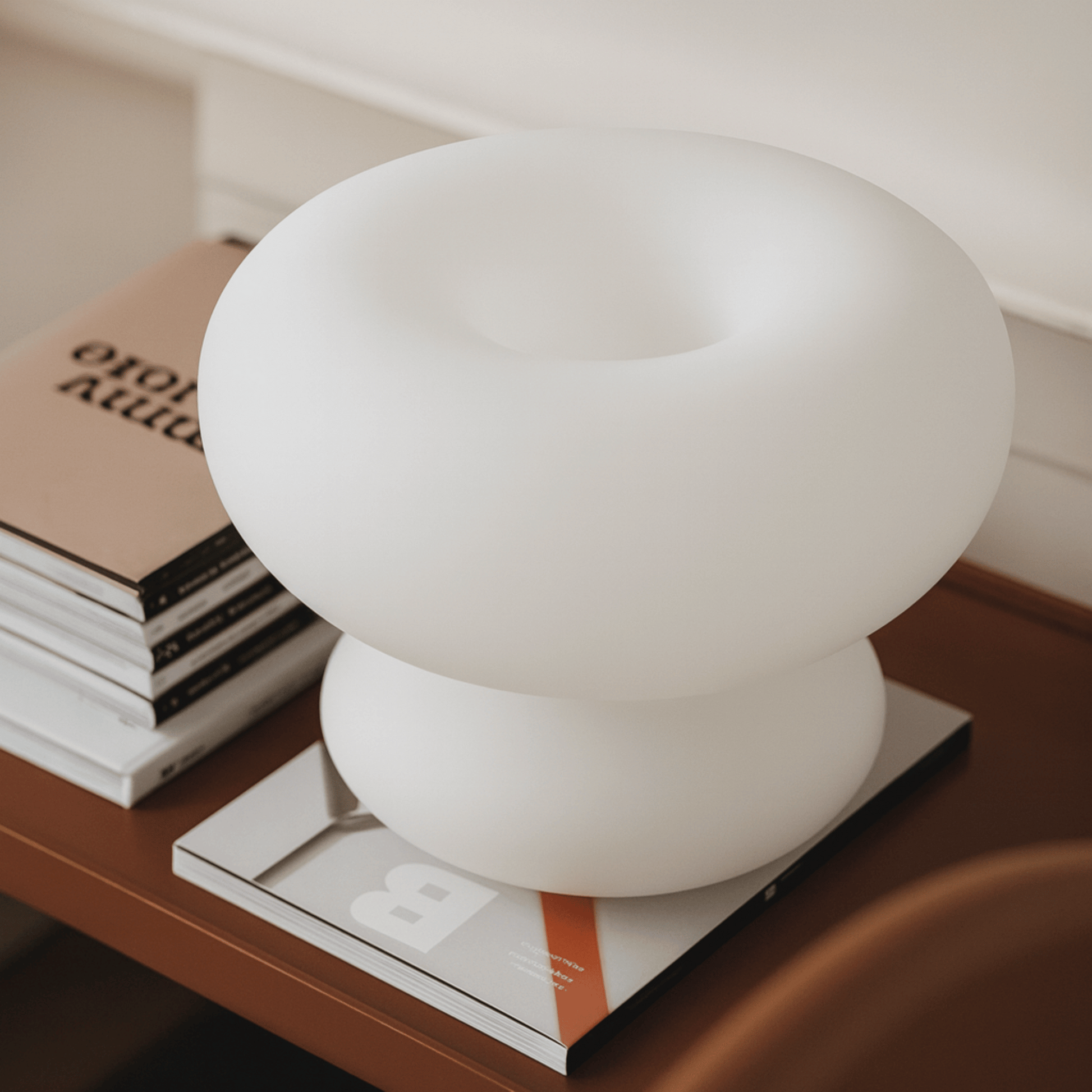 White spherical lamp on a stack of books with a blurred background