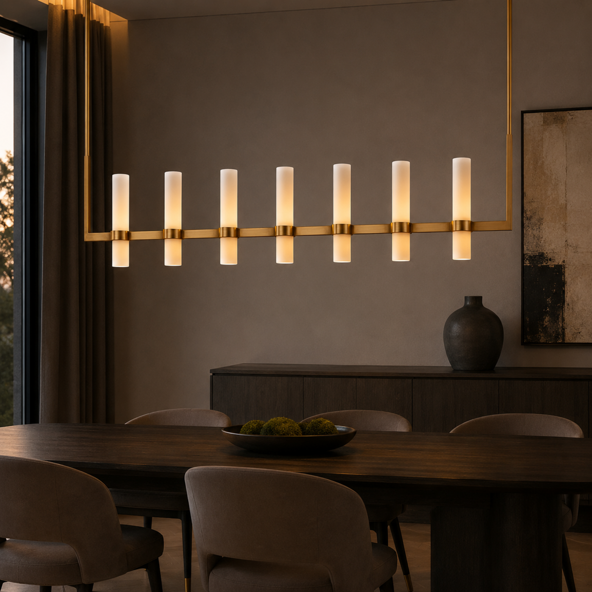 Modern dining room with a long linear chandelier, wooden table, and chairs.