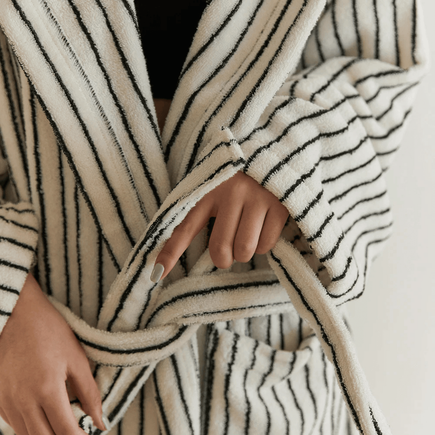 Close-up of a person wearing a black and white striped robe with a blurred background