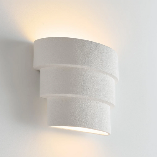 White cylindrical wall light fixture on a white background