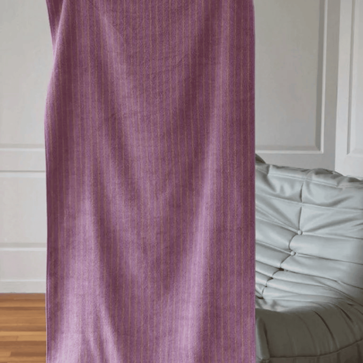 Purple curtain partially covering a bed with white bedding in a room.