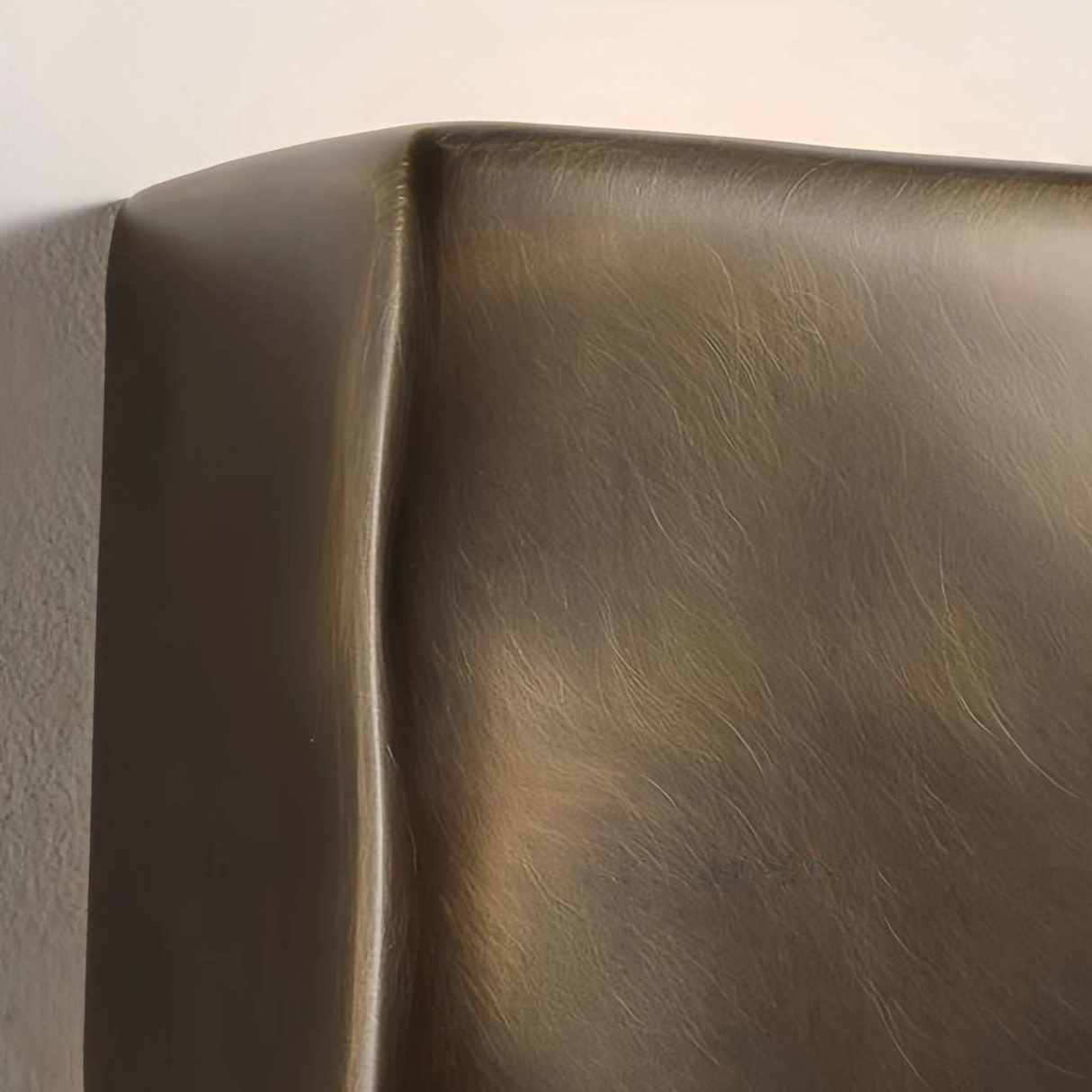 Close-up of a bronze or copper-colored metal surface with a textured finish.