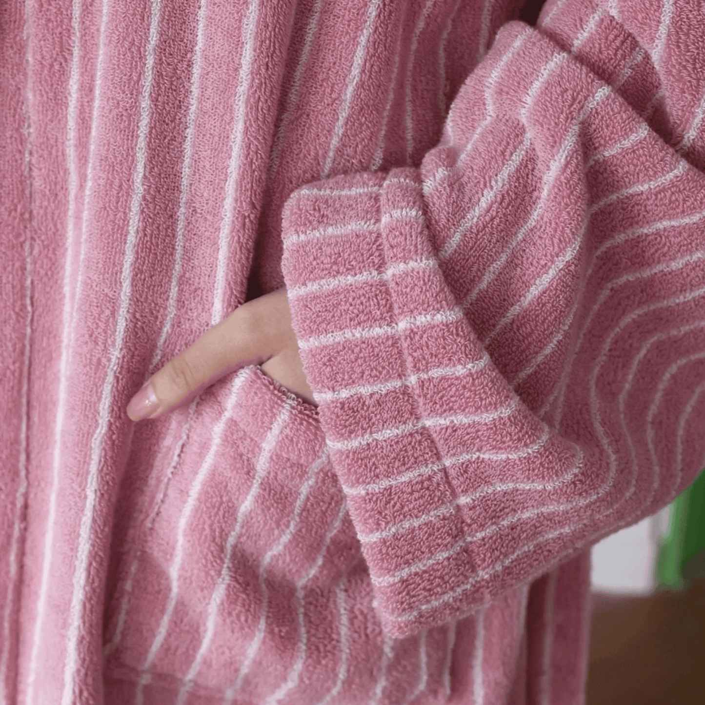 Close-up of a pink robe with white stripes worn by a person.