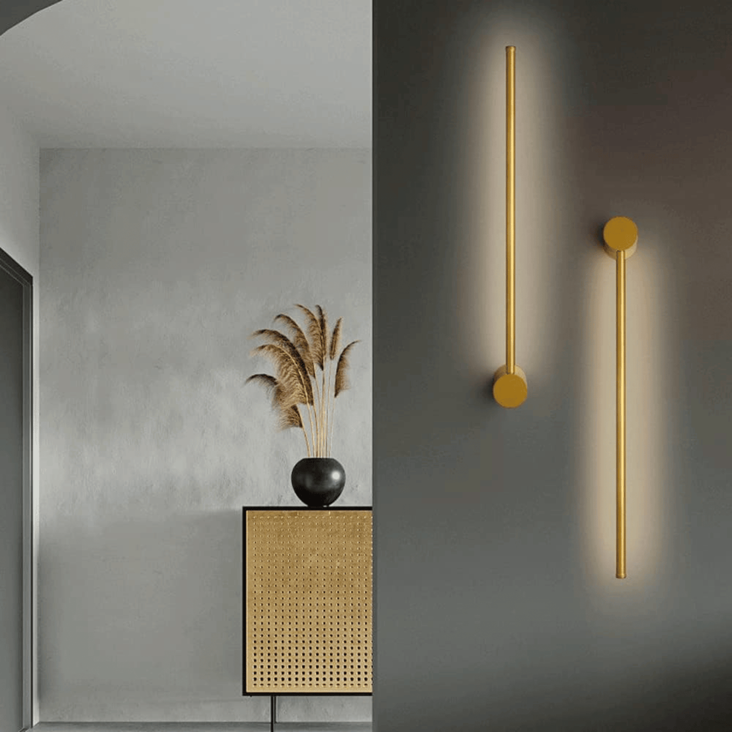 Gold wall sconces on a gray wall with a decorative plant and cabinet.