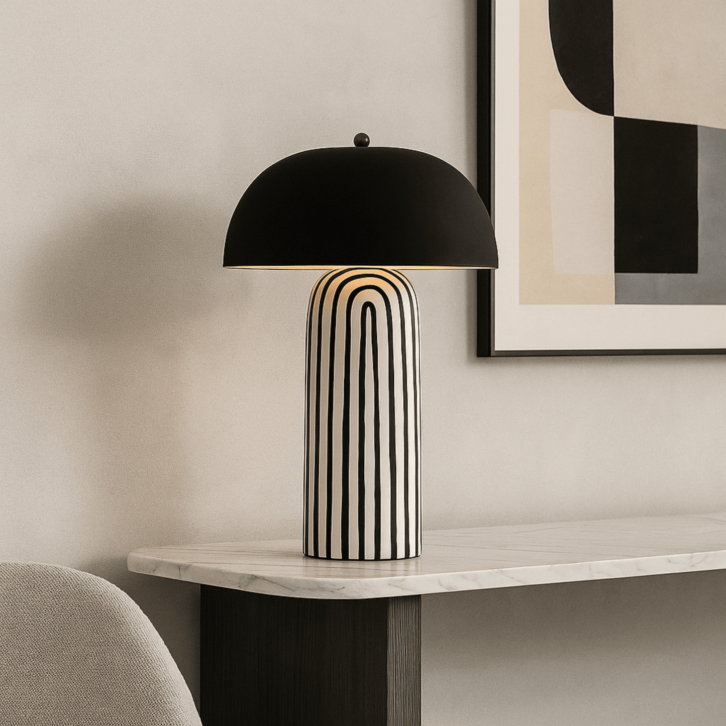 Modern table lamp with black dome shade on a marble surface, abstract art in the background.