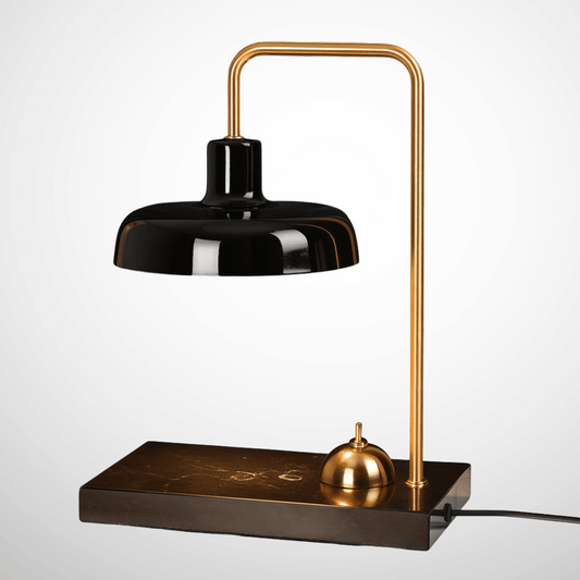 Modern desk lamp with black shade and gold arm on a white background