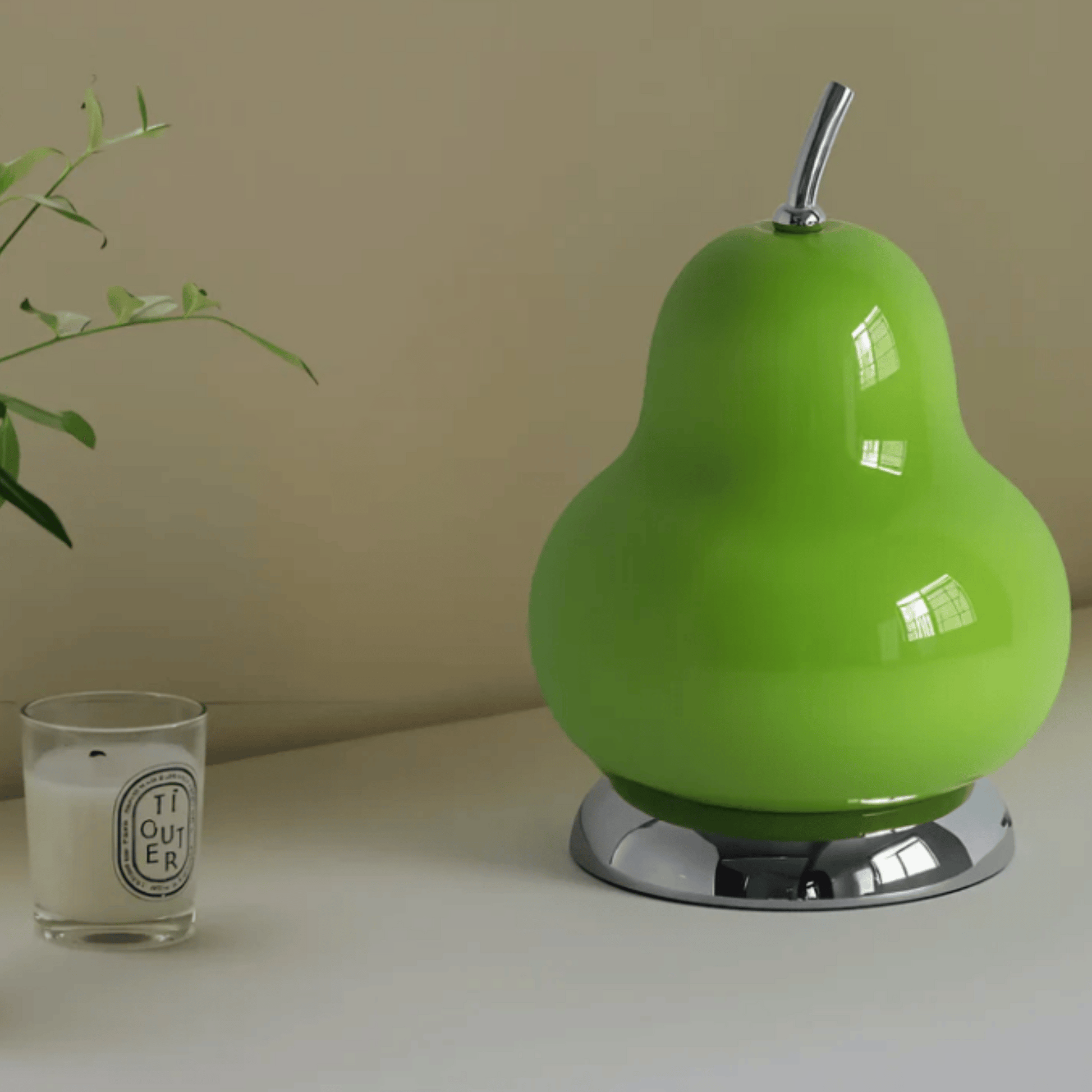 Green pear-shaped lamp with a candle on a surface