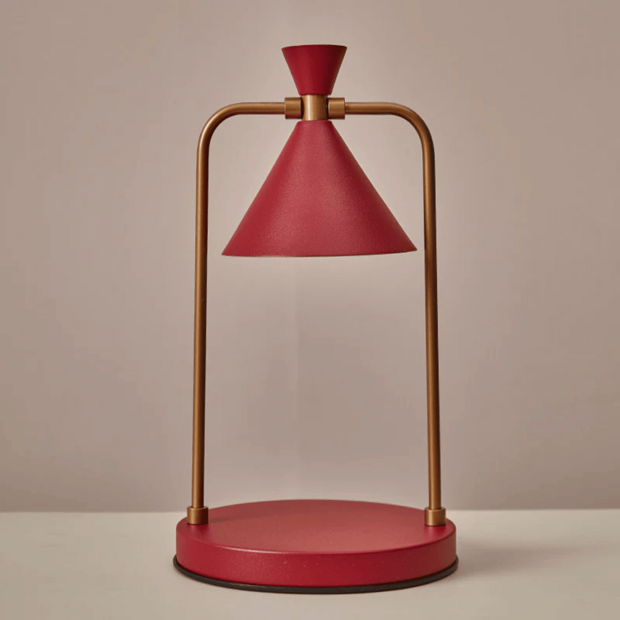 Red and gold table lamp on a beige background