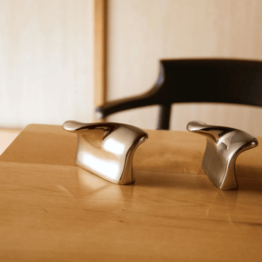 Metallic handles on a wooden surface with a blurred background