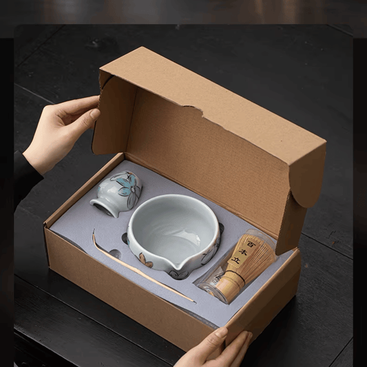 Tea set in a cardboard box on a dark surface