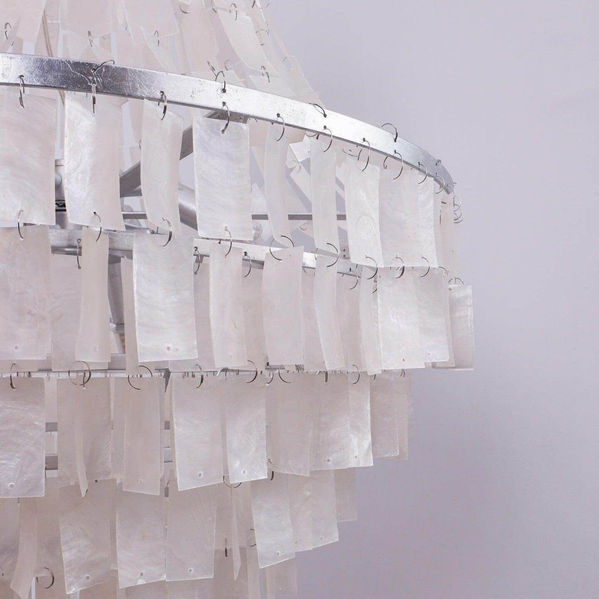 Chandelier with sheer white curtains on a plain background