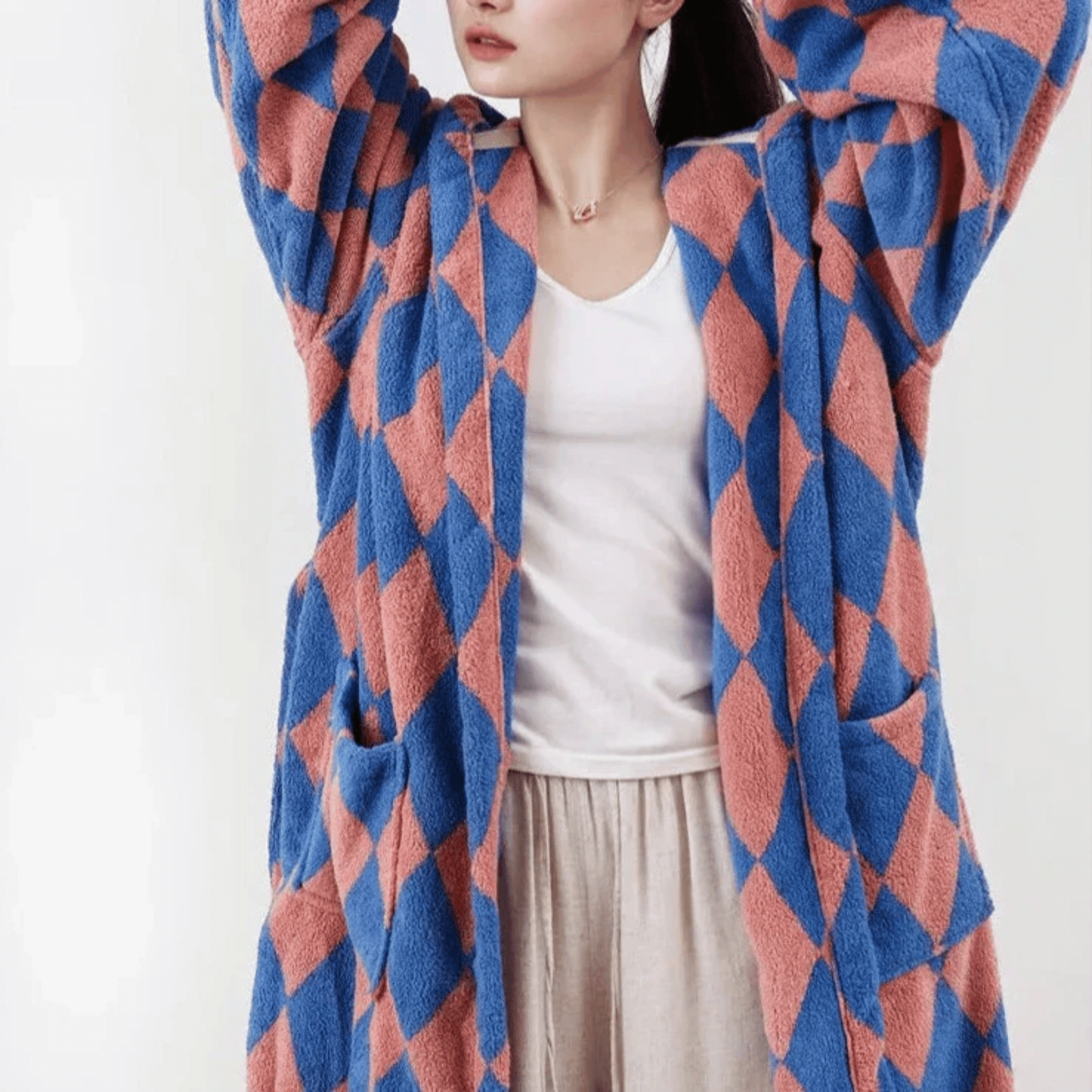 Person wearing a blue and red patterned cardigan on a white background
