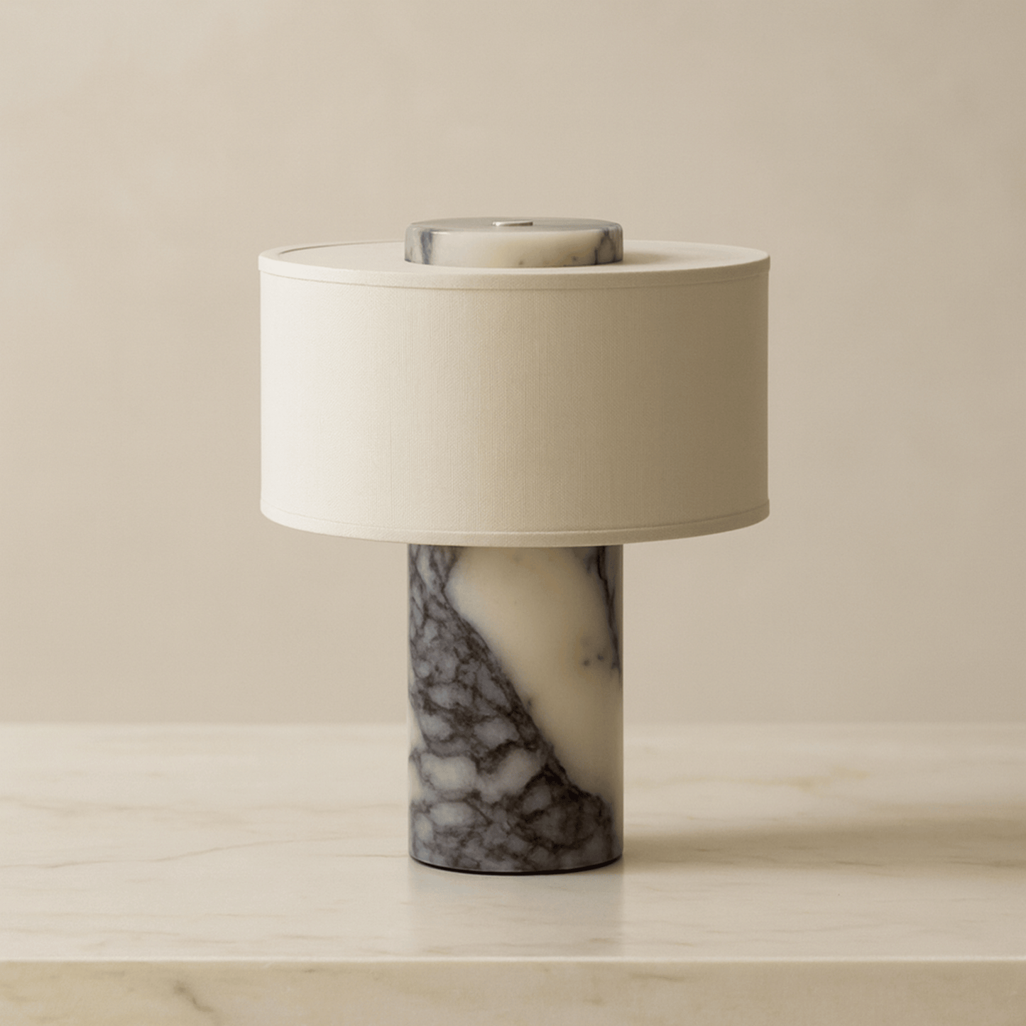 Table lamp with marble base and white shade on a beige surface