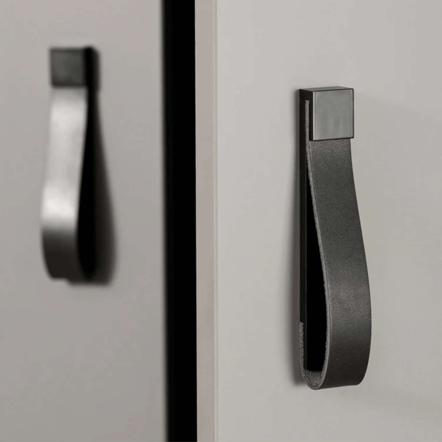 Black cabinet handle on a gray cabinet door