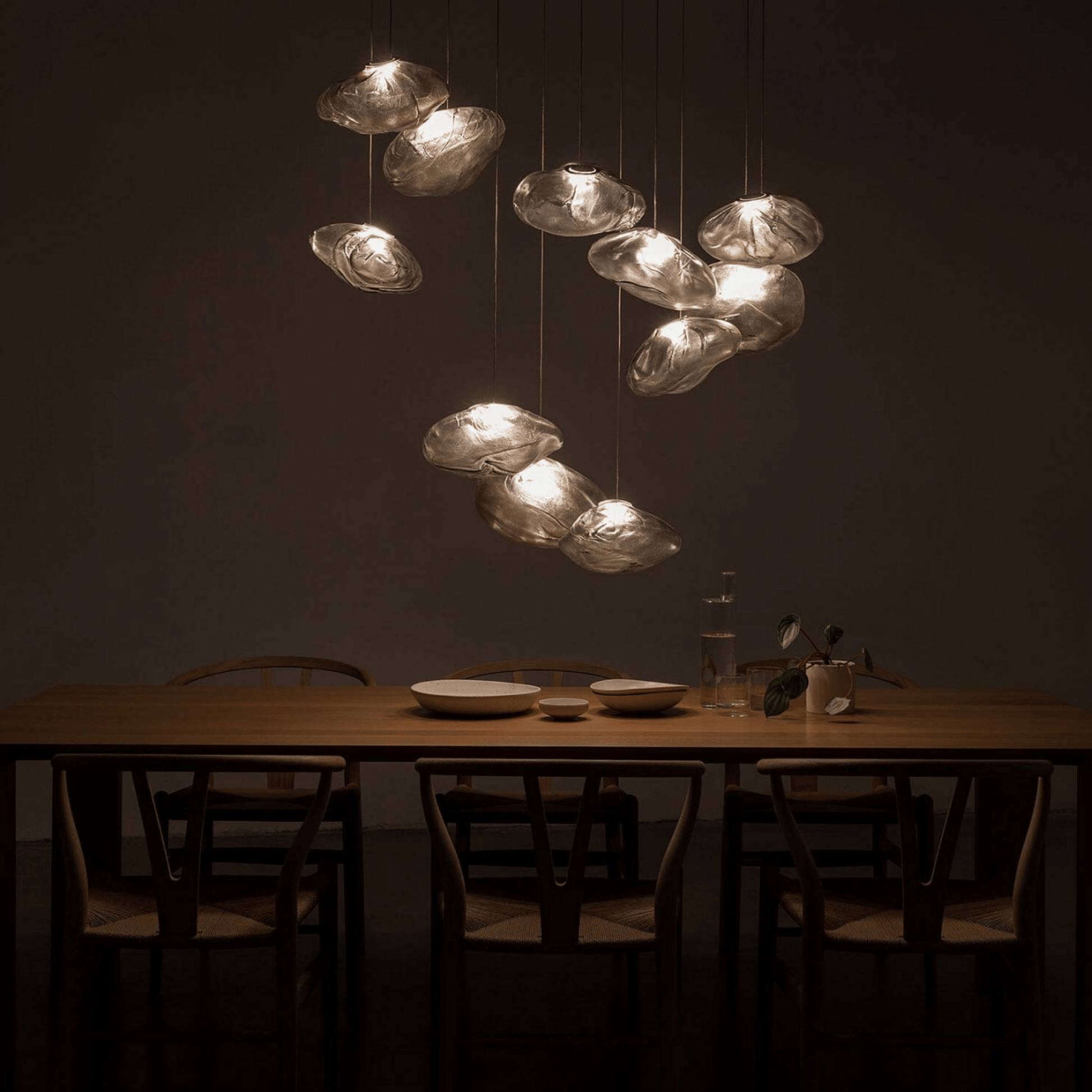 Dining table with chairs and a modern chandelier in a dimly lit room