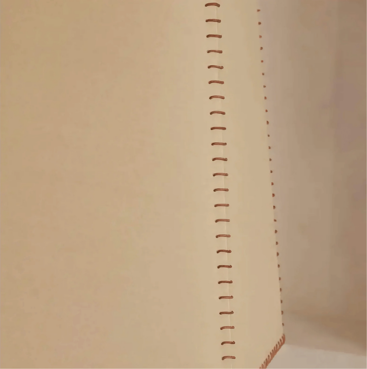 Close-up of a beige fabric with a vertical stitching pattern