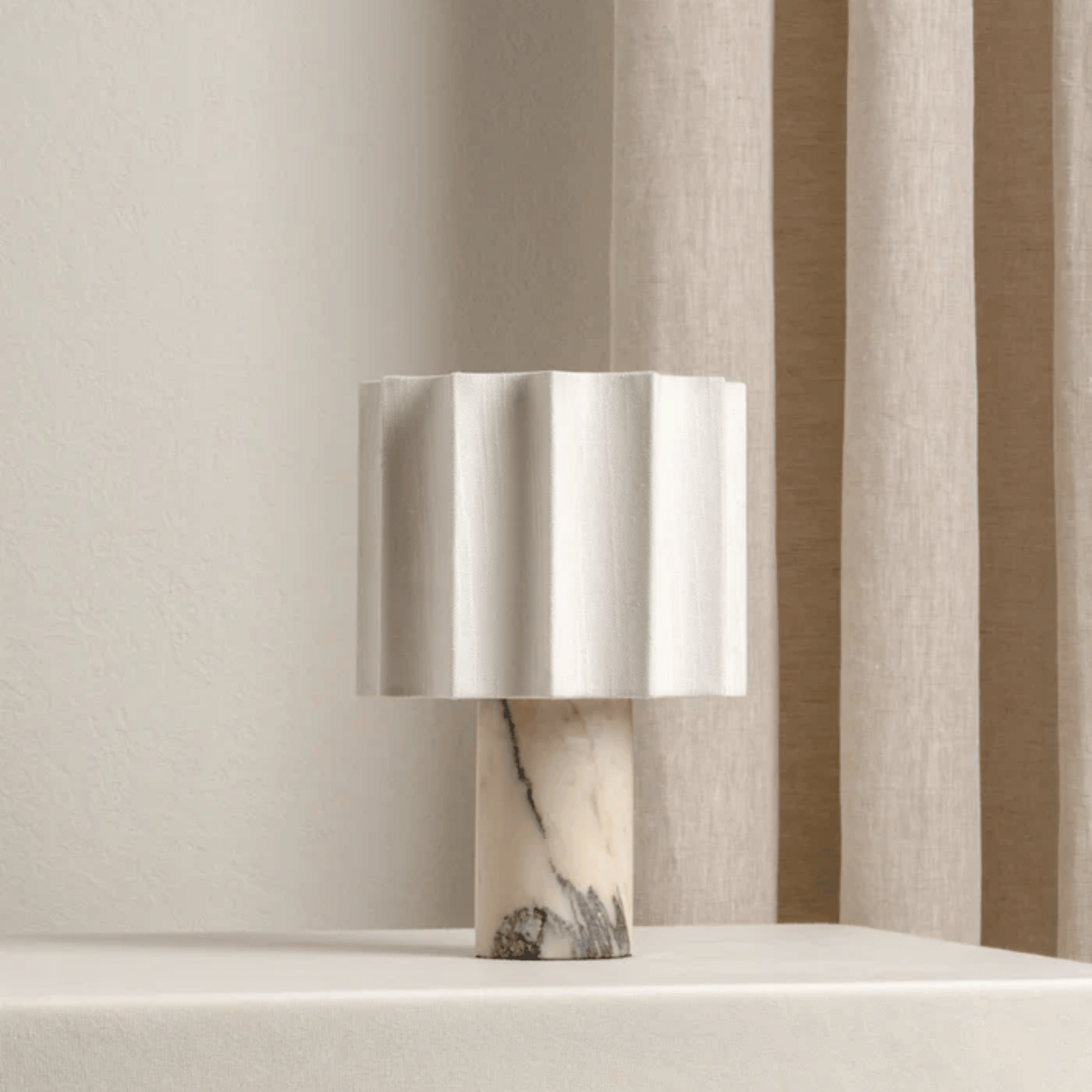 Table lamp with a marble base against a striped curtain background