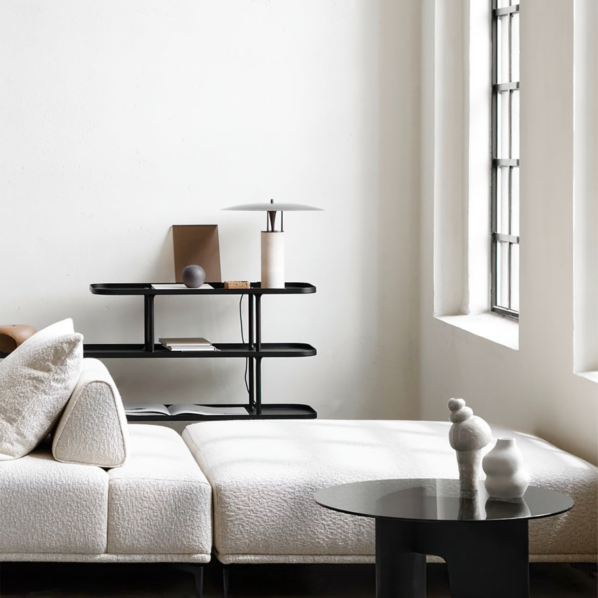 Minimal white bedroom with a bamboo lamp on a sleek side table beside a modern chair