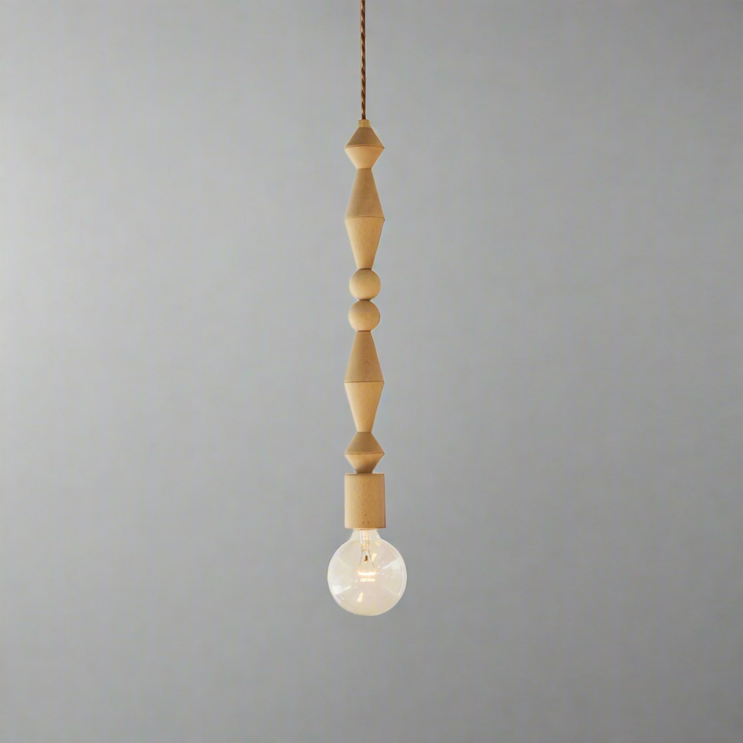 Pendant light with wooden beads and a light bulb on a white background
