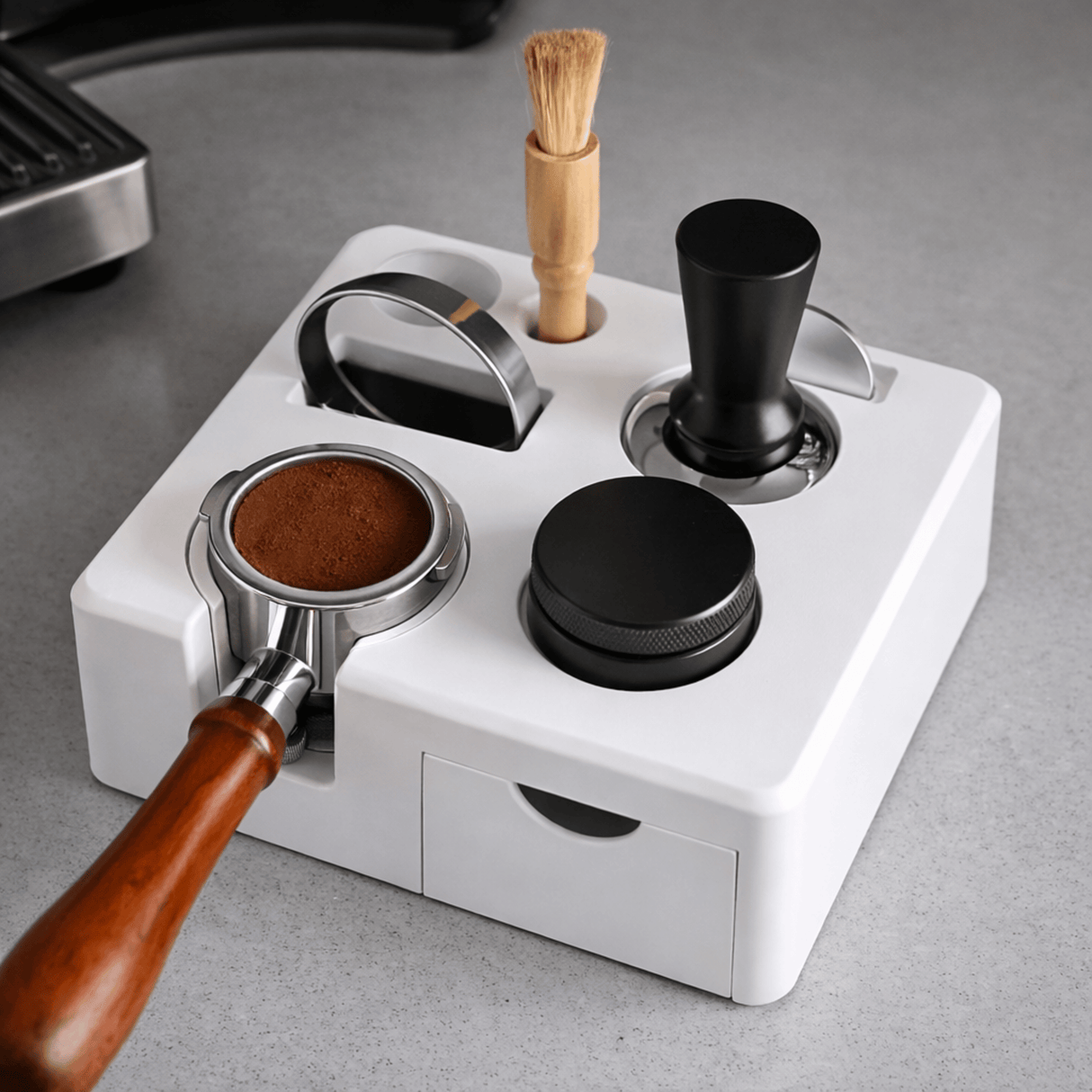 Coffee grinder with various attachments on a gray surface