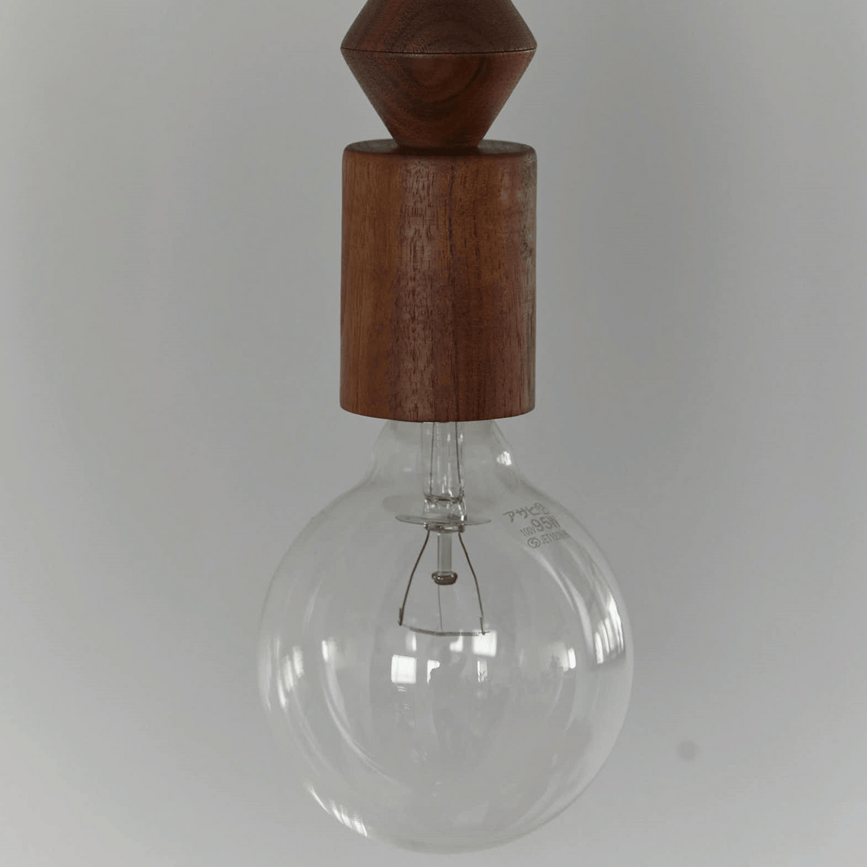 Clear glass light bulb with wooden top on a white background