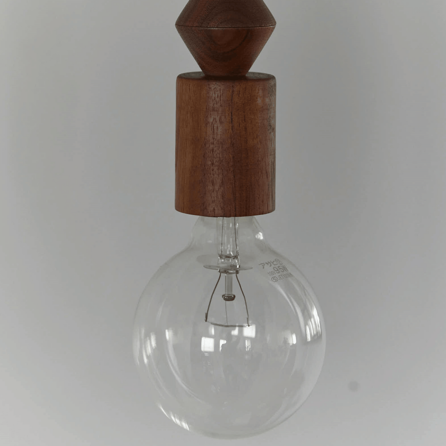 Clear glass light bulb with wooden top on a white background