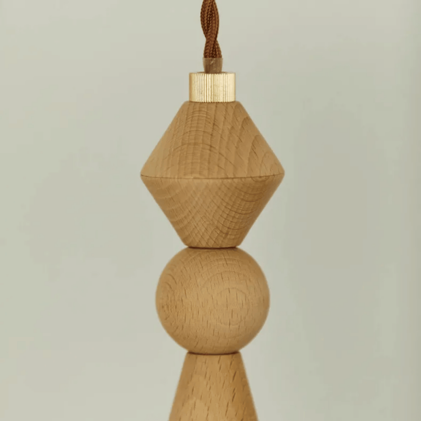 Wooden pendant light with geometric design on a plain background