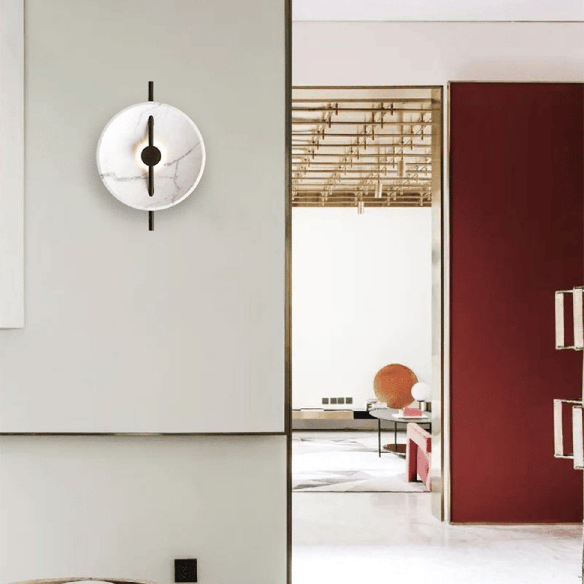 Modern wall clock on a light gray wall with a blurred room in the background