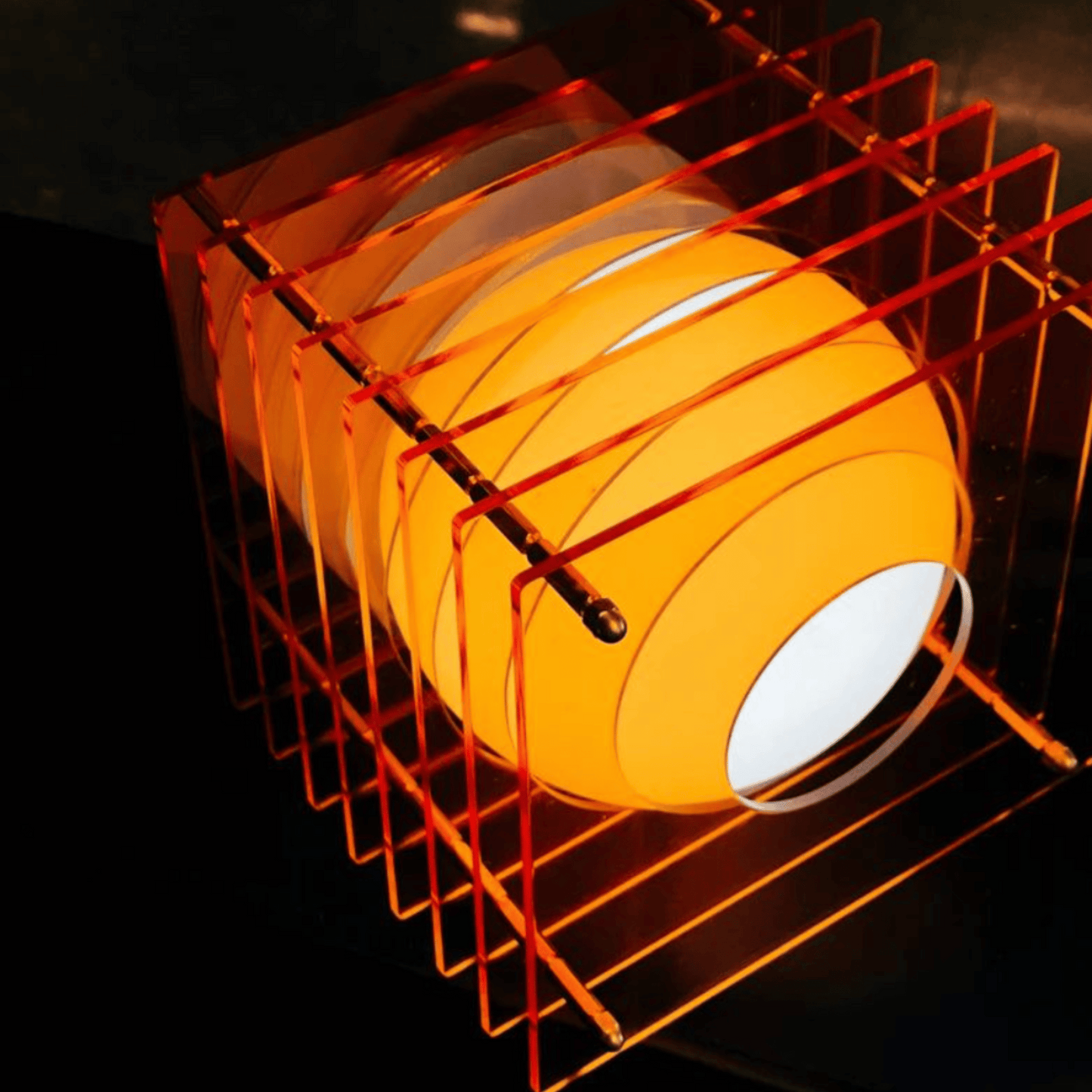 Orange lampshade with a white interior on a dark background