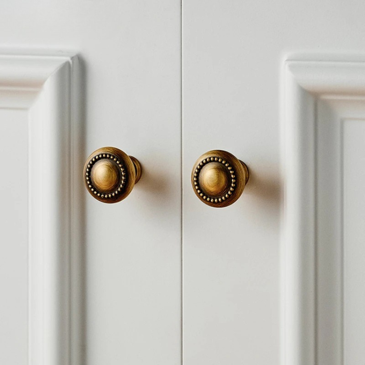 Do golden vintage-style round cabinet knobs lagaye hue white cupboard doors pe.