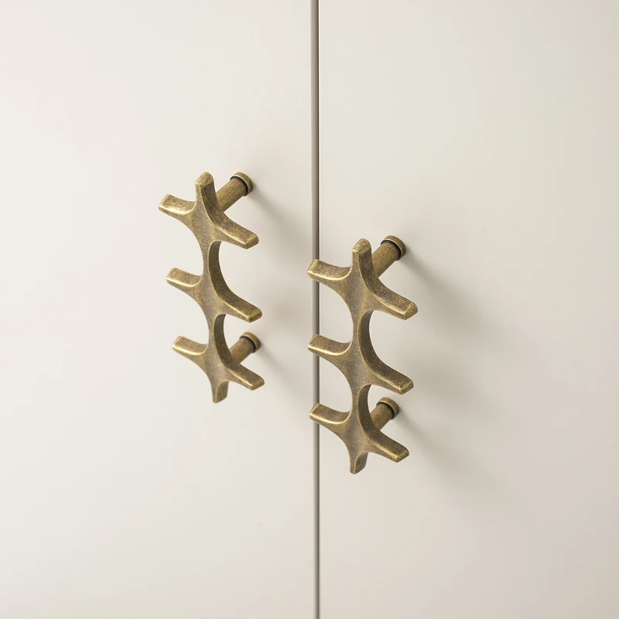 Pair of gold cabinet handles on a white door