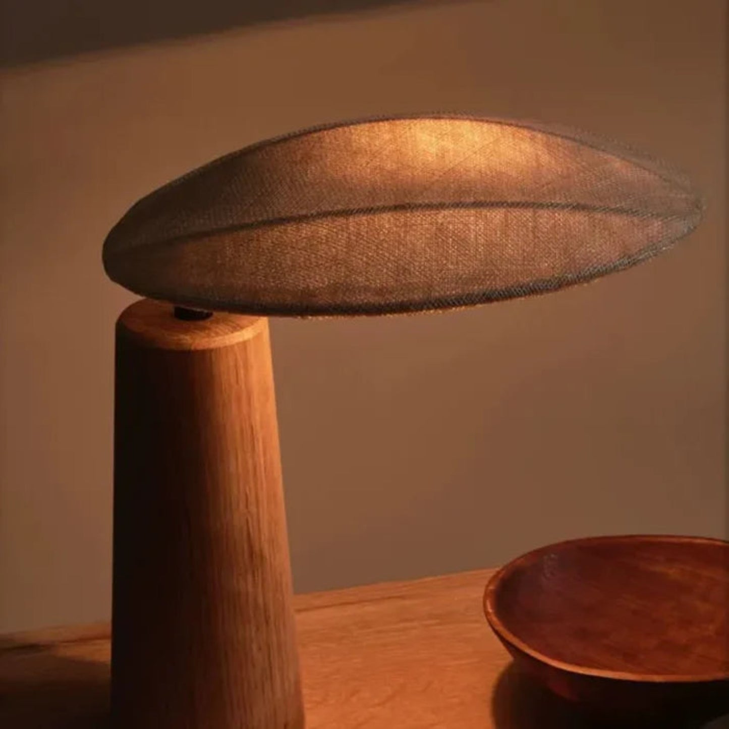 Wooden lamp with a textured shade on a wooden surface