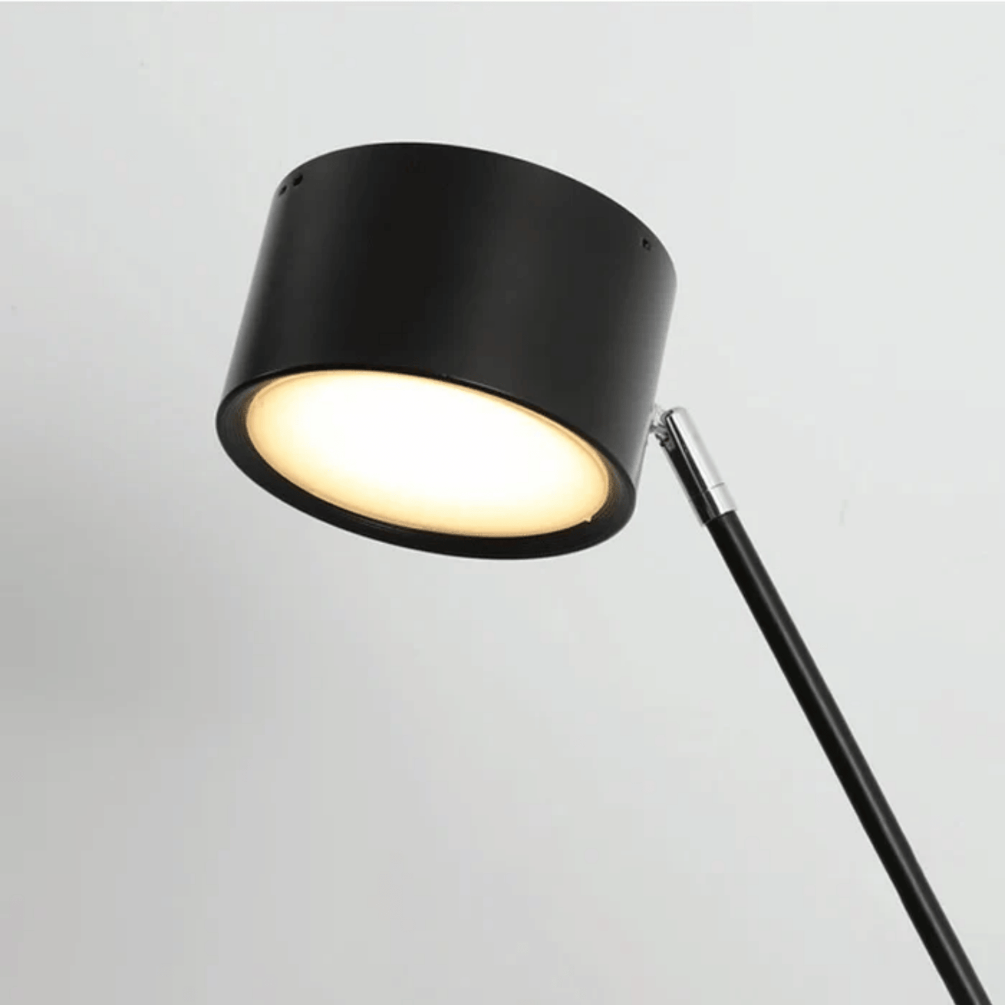 Black floor lamp with a white light on a gray background
