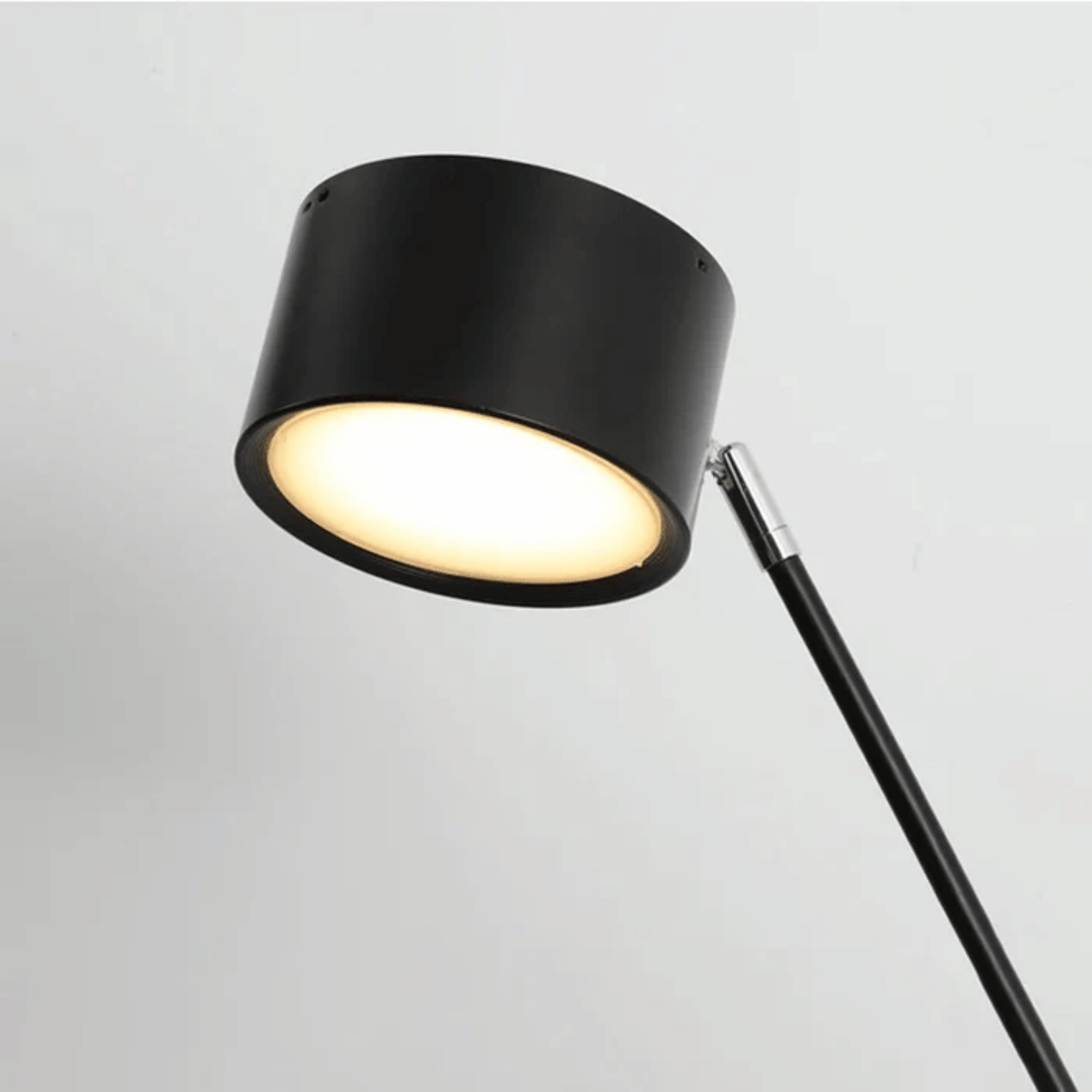 Black floor lamp with a white light on a gray background